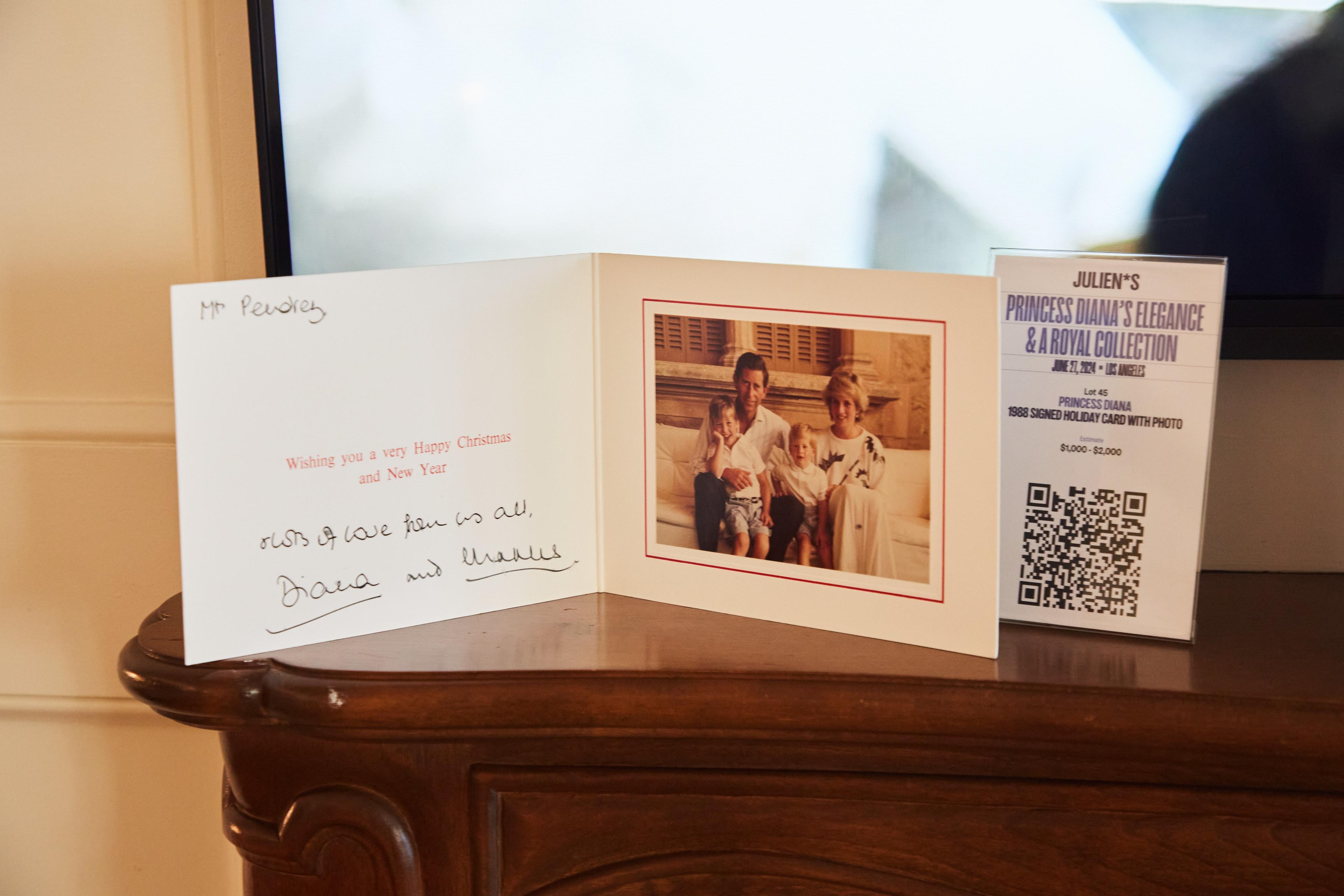 a christmas card is sitting on a wooden table next to a picture of a family .