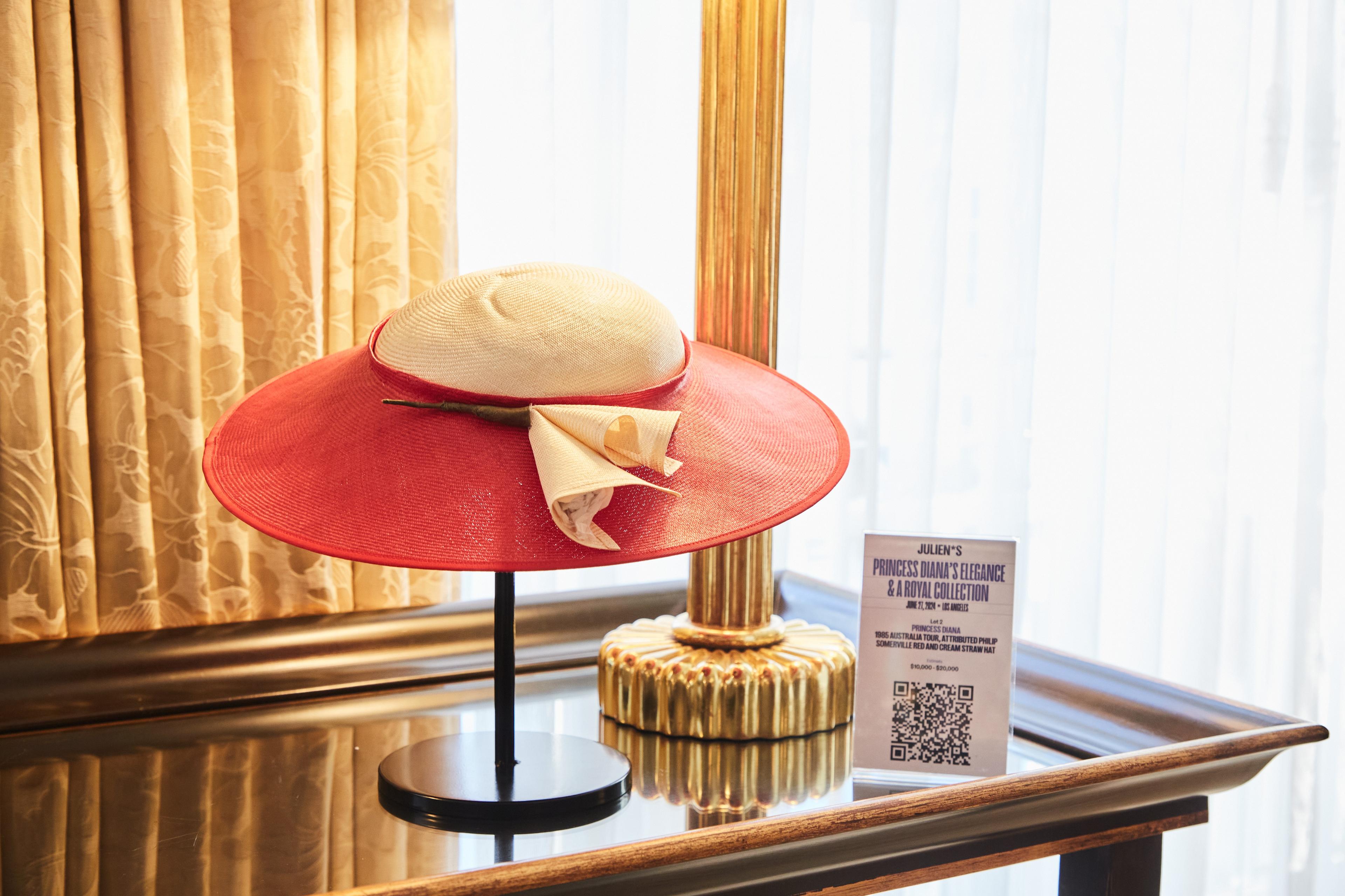 a red and white hat is sitting on a table next to a lamp .