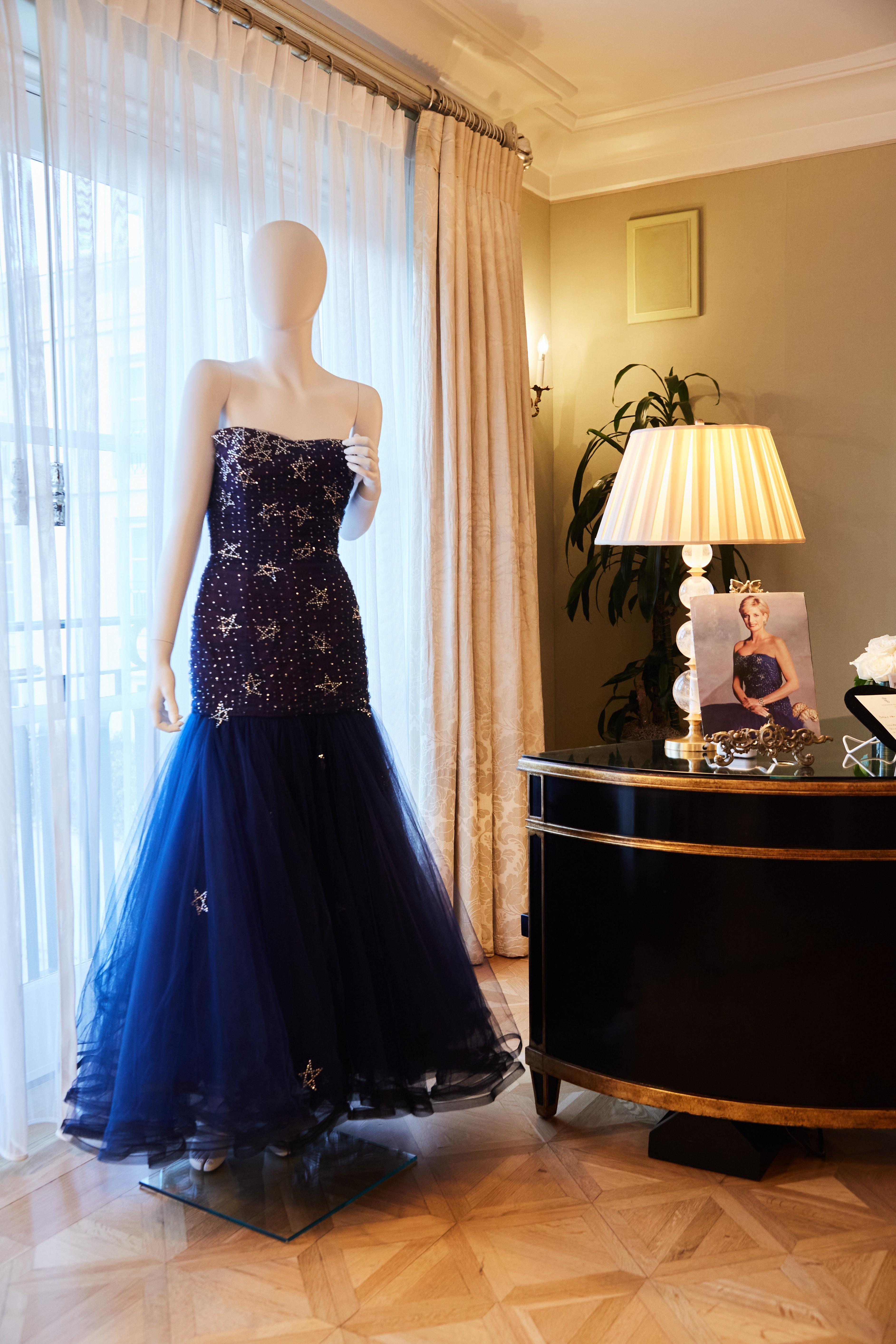 a mannequin is wearing a blue dress next to a lamp