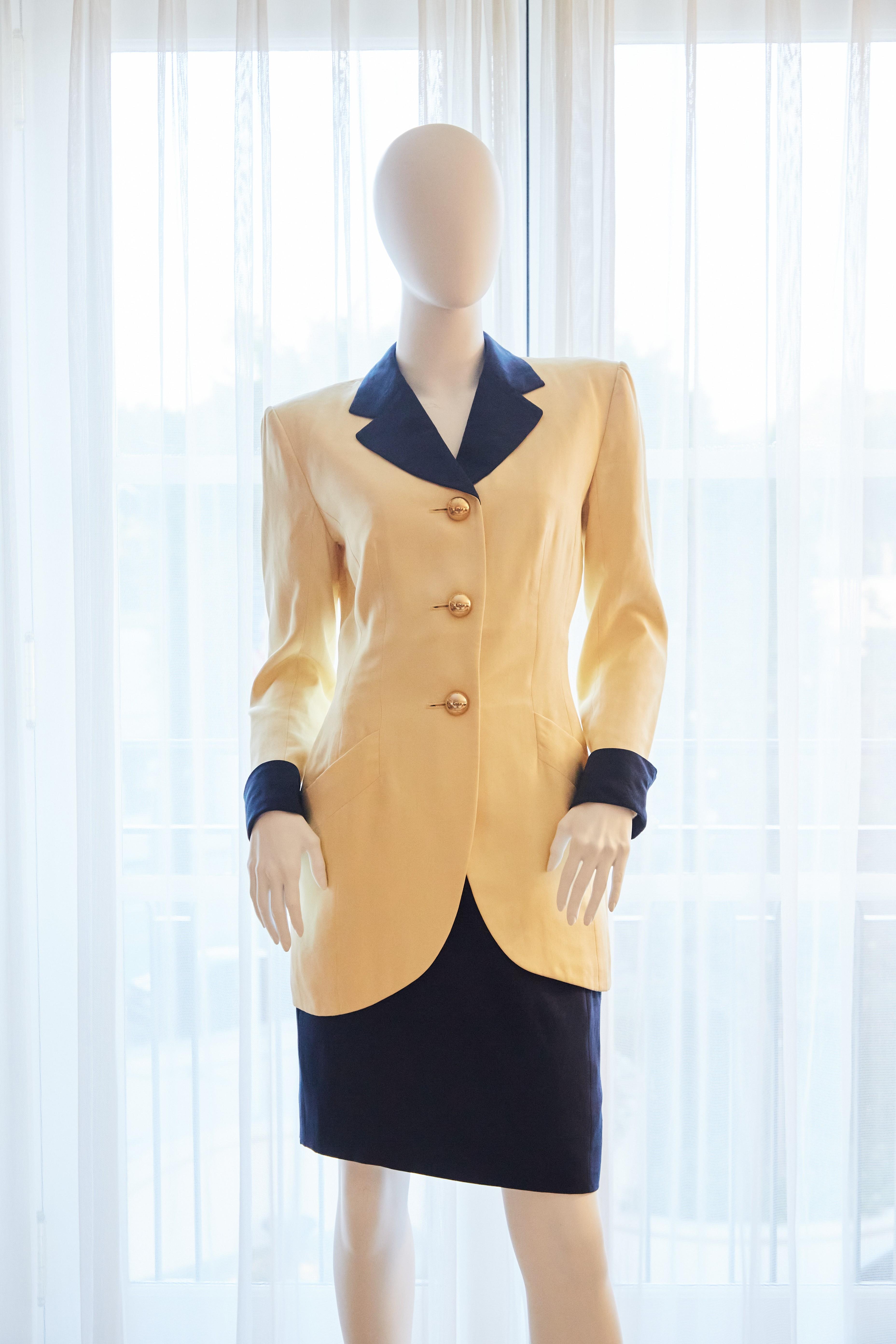 a mannequin is wearing a yellow jacket and black skirt